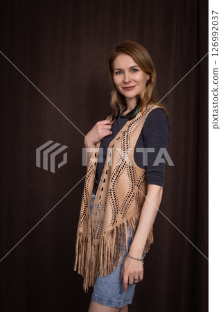 A young girl poses in a boho style suede vest. 126992037