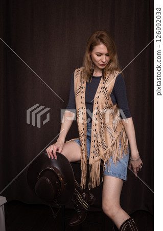 A young girl poses in a boho style suede vest. 126992038