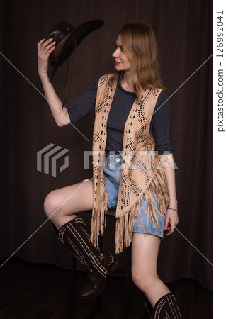 A young girl poses in a boho style suede vest. 126992041