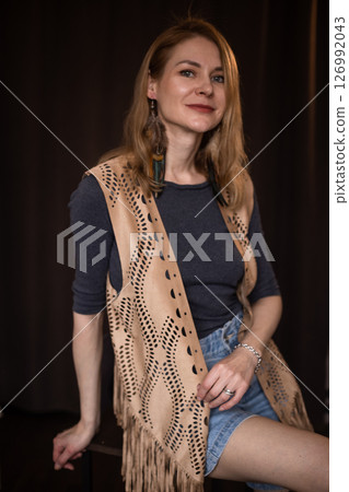 A young girl poses in a boho style suede vest. 126992043