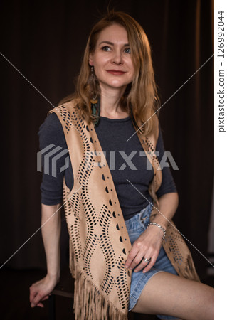 A young girl poses in a boho style suede vest. 126992044
