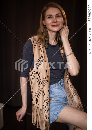 A young girl poses in a boho style suede vest. 126992045