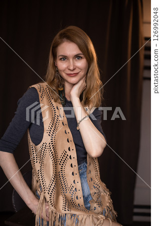 A young girl poses in a boho style suede vest. 126992048