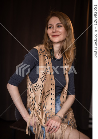 A young girl poses in a boho style suede vest. 126992051