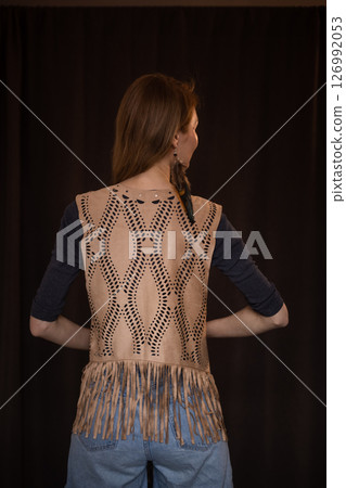 A young girl poses in a boho style suede vest. 126992053