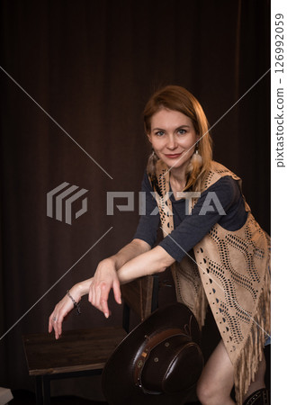 A young girl poses in a boho style suede vest. 126992059