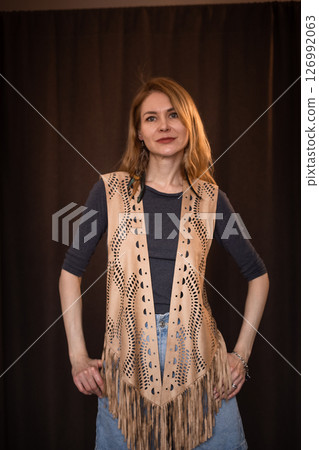 A young girl poses in a boho style suede vest. 126992063