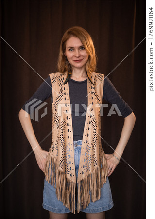 A young girl poses in a boho style suede vest. 126992064