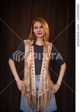 A young girl poses in a boho style suede vest. 126992065