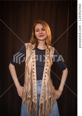 A young girl poses in a boho style suede vest. 126992068
