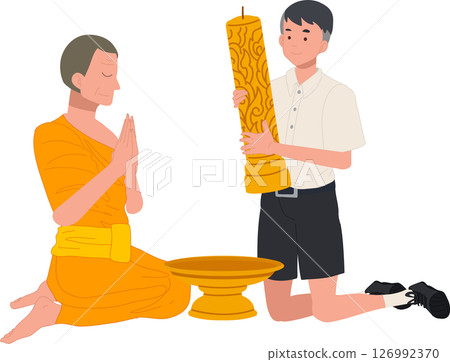 A young Thai student offers a candle to a monk during Khao Phansa at a temple 126992370