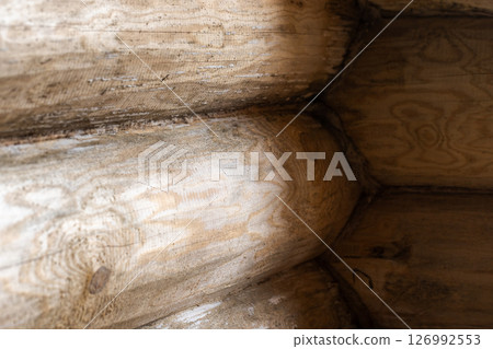 Close-up view of an interlocked wooden log wall showcasing natural textures 126992553