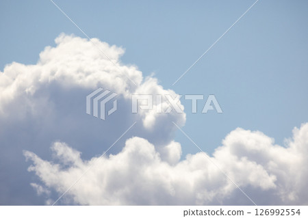 Fluffy white clouds float peacefully against a vibrant blue sky Fluffy white clouds float peacefully against a vibrant blue sky 126992554
