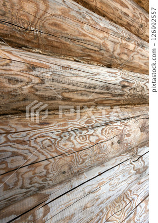 Wall of wooden logs with distinct patterns and textures, background photo 126992557