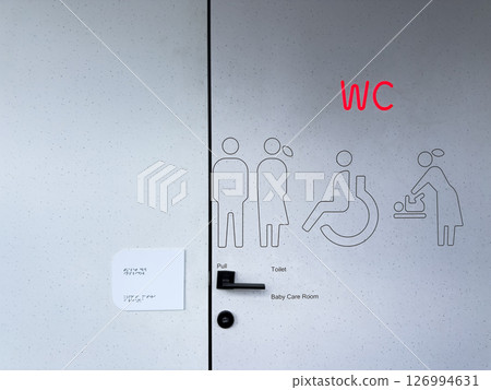 Modern public restroom door with illuminated WC sign, inclusive pictograms for men, women, disabled persons, and baby care. Accessible and universal design in public infrastructure Modern public restroom door with illuminated WC sign, inclusive pictograms for men, women, disabled persons, and baby care. Accessible and universal design in public infrastructure 126994631
