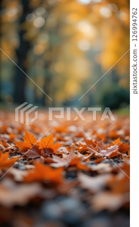 Golden Autumn Leaves Blanketing a Path in a Blurry Park 126994762