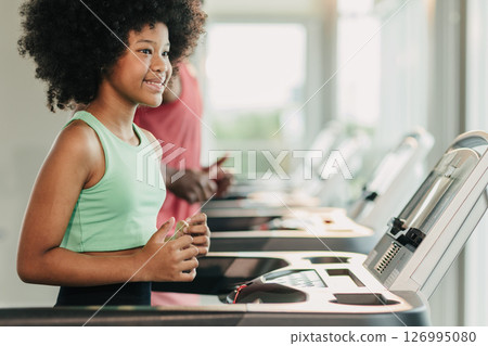 African black healthy kid, Girl child enjoy activity at fitness sport club holiday treadmill running African black healthy kid, Girl child enjoy activity at fitness sport club holiday treadmill running 126995080