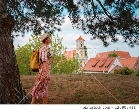 Beautiful woman walking of Varazdin streets during summer day in old, historical city center. Tourist exploring the beautiful streets, view on city from fortess 126995411