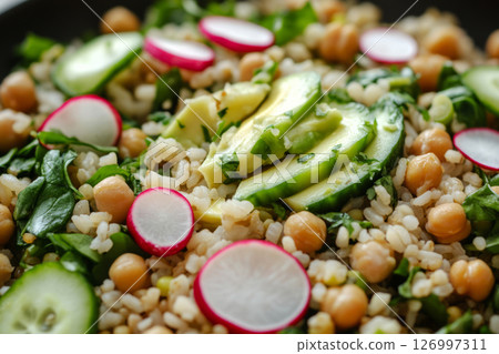 A vibrant breakfast bowl showcasing sliced avocado, chickpeas, fresh arugula, and radishes arranged beautifully in a cozy restaurant ambiance 126997311