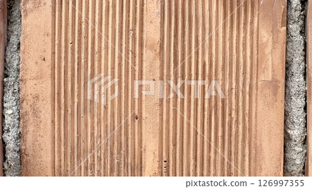 Textured clay wall presents intricate details in natural light 126997355