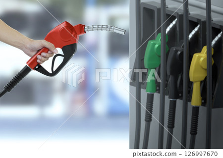 Man is Holding a fuel nozzle against with in a service station blurred background 126997670