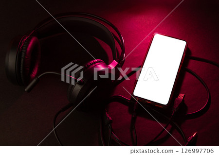 Headphones and Smartphone Setup with Red Lighting Headphones and Smartphone Setup with Red Lighting 126997706