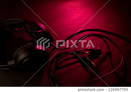 Headphones on dark red surface Headphones on dark red surface 126997709