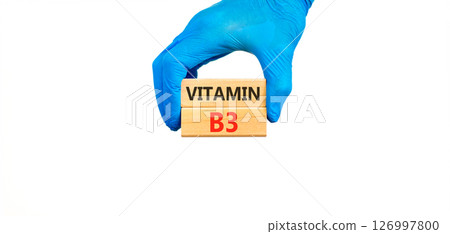 Vitamin B3 niacin symbol. Concept words Vitamin B3 on beautiful wooden blocks. Doctor's hand in blue medical glove. Beautiful white background. Medical healthy lifestyle Vitamin B3 niacin concept. 126997800