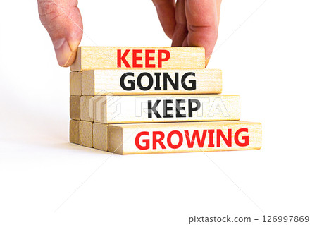 Keep going and growing symbol. Concept words phrase Keep going keep growing on beautiful wooden blocks. Beautiful white background. Businessman's hand. Business Keep going growing concept. Copy space. 126997869