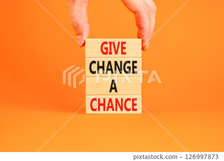 Give change a chance symbol. Concept words phrase Give change a chance on beautiful wooden blocks. Beautiful orange paper background Businessman's hand Business Give change a chance concept Copy space 126997873