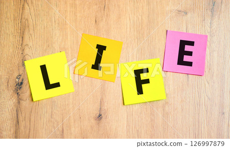 Life symbol. Concept word Life on beautiful colored paper. Beautiful wooden table wooden background. Business, lifestyle, support and life concept. Copy space. Life symbol. Concept word Life on beautiful colored paper. Beautiful wooden table wooden background. Business, lifestyle, support and life concept. Copy space. 126997879