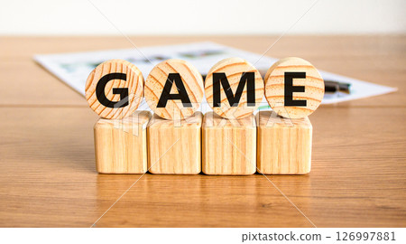 Game symbol. Concept word Game on beautiful wooden circles on wooden blocks. Beautiful wooden table white background. Business, lifestyle and game concept. Copy space. Game symbol. Concept word Game on beautiful wooden circles on wooden blocks. Beautiful wooden table white background. Business, lifestyle and game concept. Copy space. 126997881