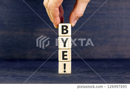 Bye symbol. Concept word Bye on beautiful wooden blocks. Businessman hand. Beautiful black table black background. Business and bye concept. Copy space. Bye symbol. Concept word Bye on beautiful wooden blocks. Businessman hand. Beautiful black table black background. Business and bye concept. Copy space. 126997895