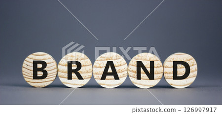 Brand symbol. Concept word Brand on beautiful wooden circles. Beautiful grey table grey background. Business brand concept. Copy space. 126997917