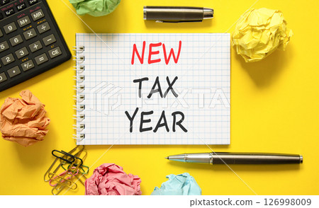 New tax year symbol. Concept words New tax year on beautiful white note. Beautiful yellow background. Black pen. Black calculator. Business new tax year concept. Copy space. 126998009