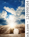 The stone rolled away from the entrance of empty tomb with sunlight bursting through, symbolizing Easter and the resurrection of Jesus Christ 126998164