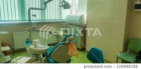 Modern dental clinic, dental chair and other accessories used by dentists. Concept of pediatric dentistry, treatment of oral diseases. Modern dental clinic, dental chair and other accessories used by dentists. Concept of pediatric dentistry, treatment of oral diseases. 126998188