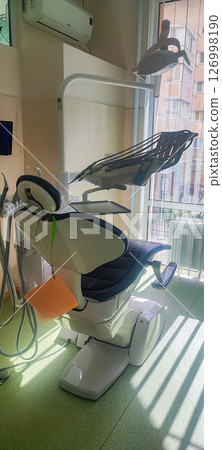 Modern dental clinic, dental chair and other accessories used by dentists. Concept of pediatric dentistry, treatment of oral diseases. 126998190