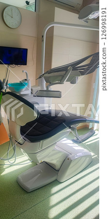 Modern dental clinic, dental chair and other accessories used by dentists. Concept of pediatric dentistry, treatment of oral diseases. Modern dental clinic, dental chair and other accessories used by dentists. Concept of pediatric dentistry, treatment of oral diseases. 126998191