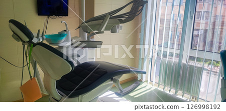 Modern dental clinic, dental chair and other accessories used by dentists. Concept of pediatric dentistry, treatment of oral diseases. Modern dental clinic, dental chair and other accessories used by dentists. Concept of pediatric dentistry, treatment of oral diseases. 126998192
