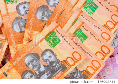 100 peso bills from Dominican Republic showcase their intricate designs hues in neat arrangement. 100 peso bills from Dominican Republic showcase their intricate designs hues in neat arrangement. 126998244
