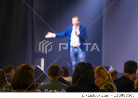 Speaker addressing audience during a conference under focused lights 126998505