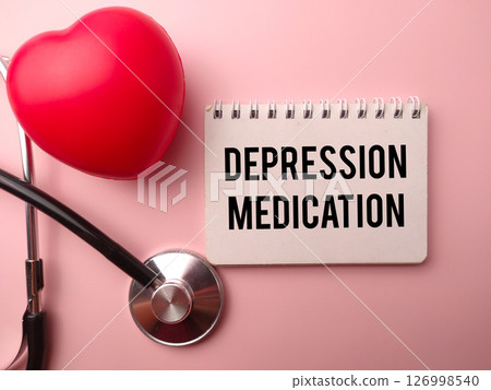 Red heart shape and statehoscope with the word DEPRESSION MEDICATION on a pink background. 126998540