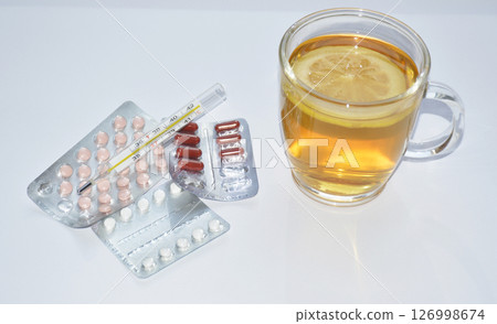 pills, thermometer and tea with lemon on white background 126998674