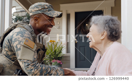 Armed Forces Day smiling african american male soldier in uniform greeting elderly woman outside home 126999440