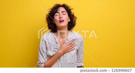Woman suffering from chest pain holding chest area showing symptoms of heart or health issue Woman suffering from chest pain holding chest area showing symptoms of heart or health issue 126999607