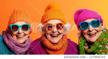 Brightly dressed elderly women enjoy a cheerful moment together, showcasing vibrant colors and joyful expressions in a sunny, warm atmosphere Brightly dressed elderly women enjoy a cheerful moment together, showcasing vibrant colors and joyful expressions in a sunny, warm atmosphere 127000143