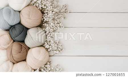 Pastel yarn balls and delicate flowers on white wooden background with empty space. Banner for knitting stores and blogs 127001655