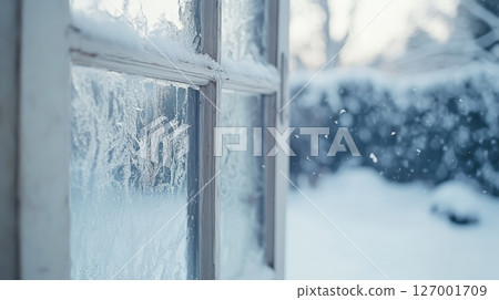 Frosty window with snow falling outside, winter scene. Tranquil and serene weather concept Frosty window with snow falling outside, winter scene. Tranquil and serene weather concept 127001709