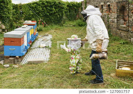 The beekeeper shows the beehive to the children 127001757
